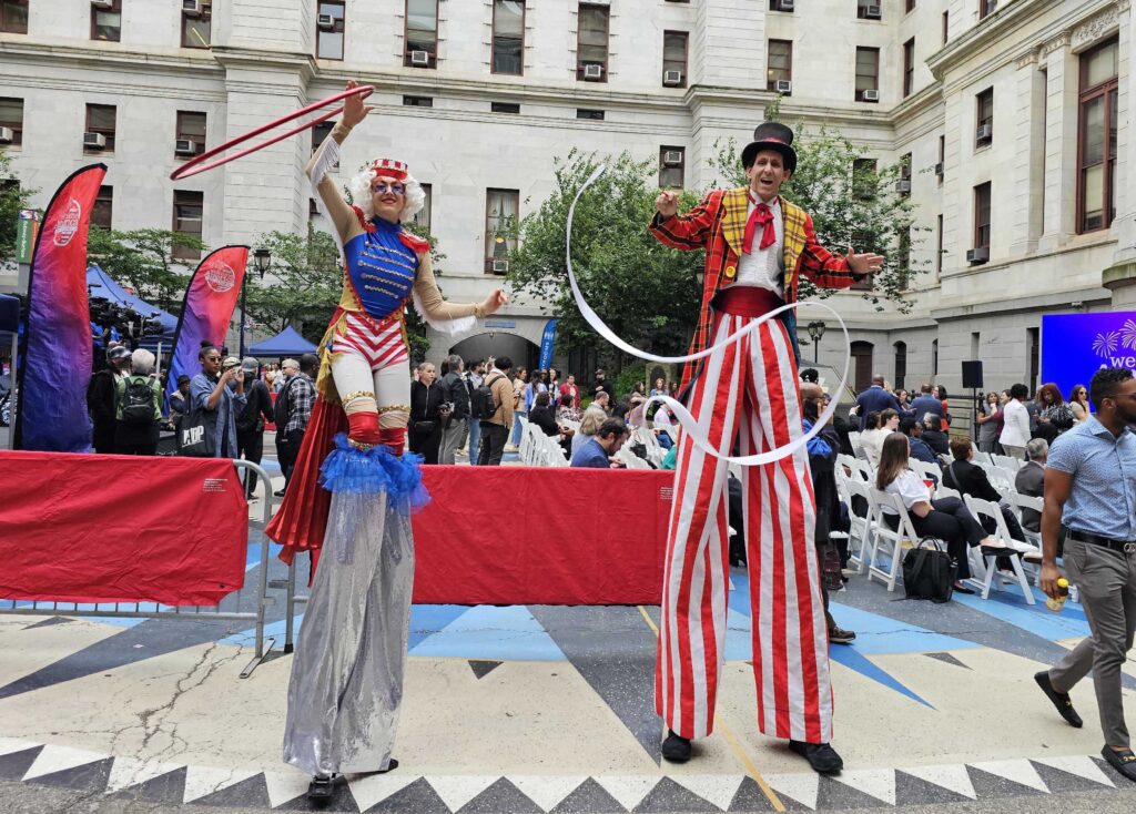 2 people dressed in costumes on stilts