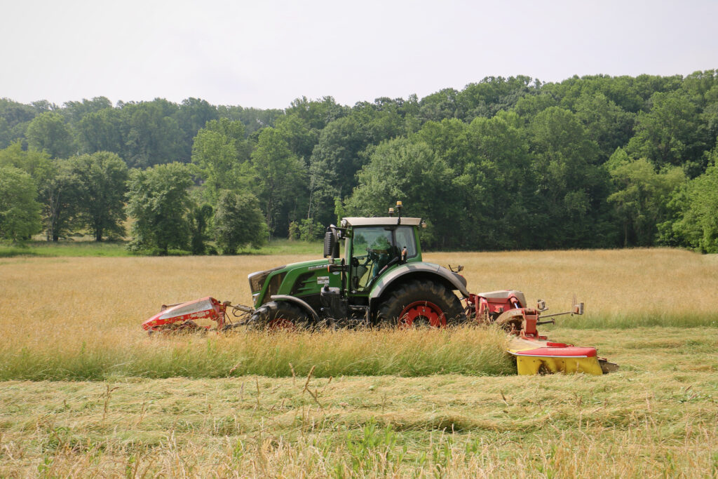 a tractor mows a field for hay