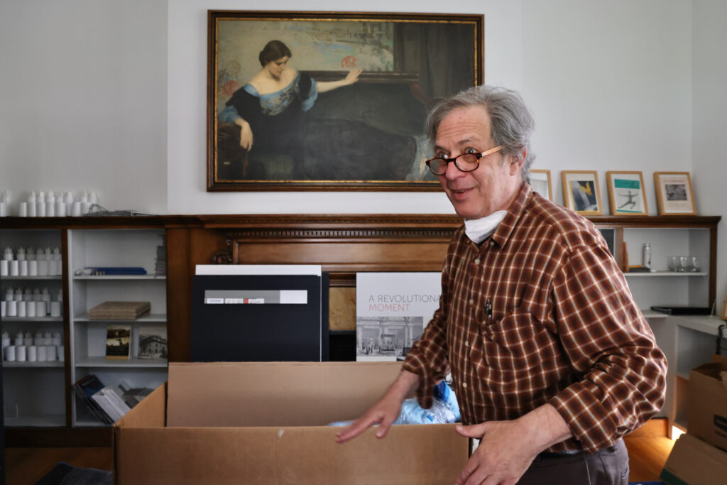 Sid Sachs packs up beneath a painting of Christine Wetherill Stevenson