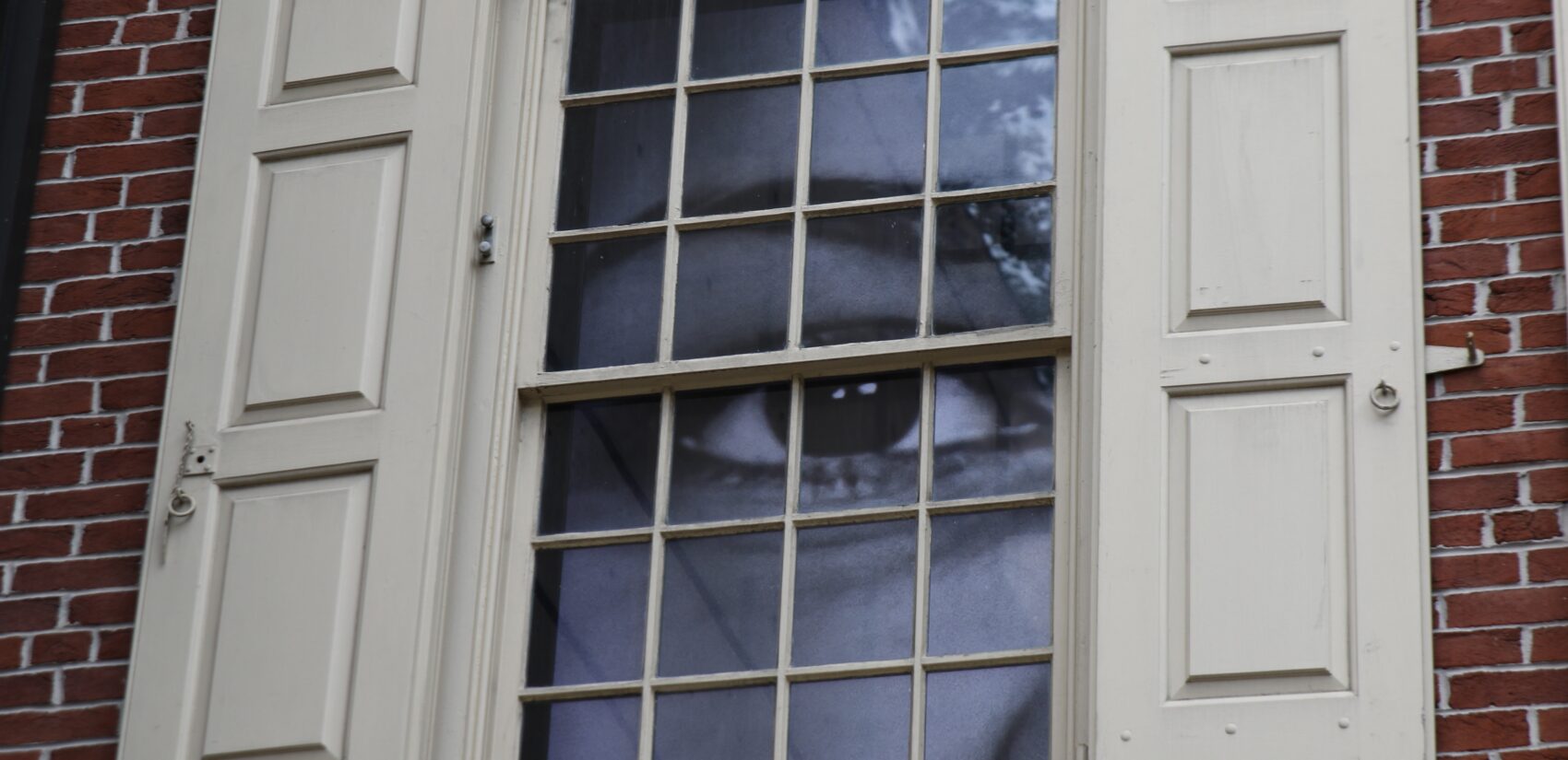 a large eye is seen through a window