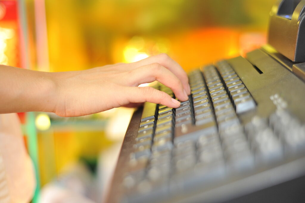 Woman’s hand on cash register buttons Woman's hand on cash register buttons