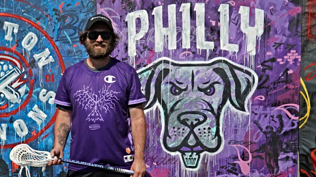 canine-crew-water-dogs-n-kariuki-2024-06-17 AJ Kerrigan holding a lacrosse stick