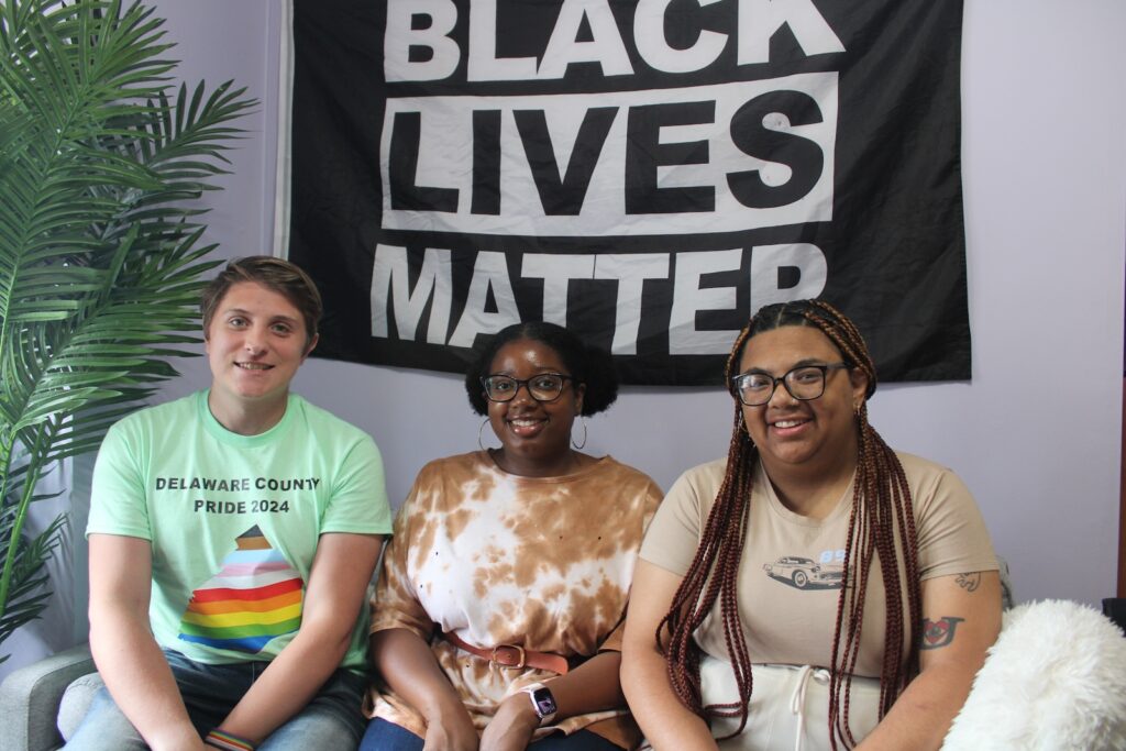 delco-community-center-1-EN-060724 Kyle McIntyre, Dyamond Gibbs and Kayla Cocci are seen sitting on a couch under a Black Lives Matter banner