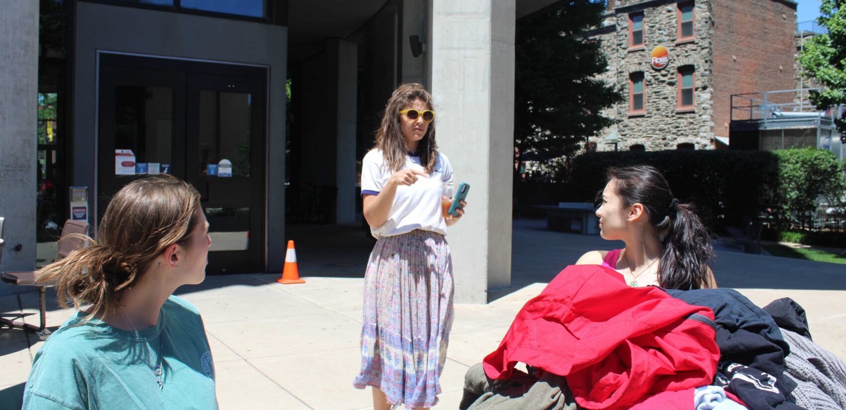 Rachel Higgins, center, professor of Design and Merchandising at Drexel University, speaks with student volunteers collecting data on clothing discarded by students during move out. (Emily Neil/WHYY)