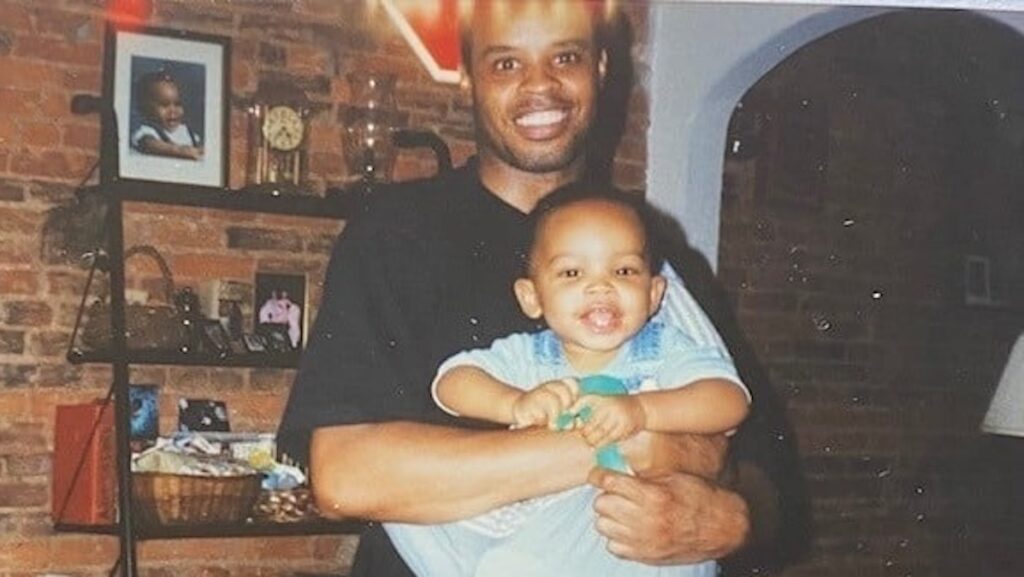 A man is holding his baby boy in his arms.