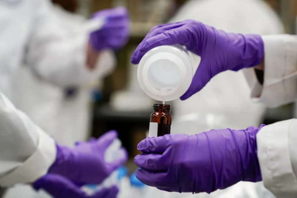 pfas-water-testing-epa-AP-060724 A water researcher pours a water sample into a smaller glass container for experimentation as part of drinking water and PFAS research