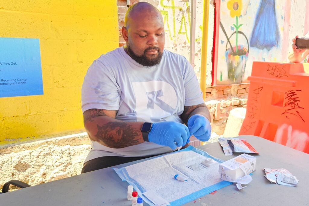 prevention-point-tests-2024-4 Kareem Mims, prevention health care coordinator at Prevention Point Philadelphia in Kensington, prepares a rapid HIV test, which involves a small finger prick and results in about 60 seconds. (Nicole Leonard/WHYY)
