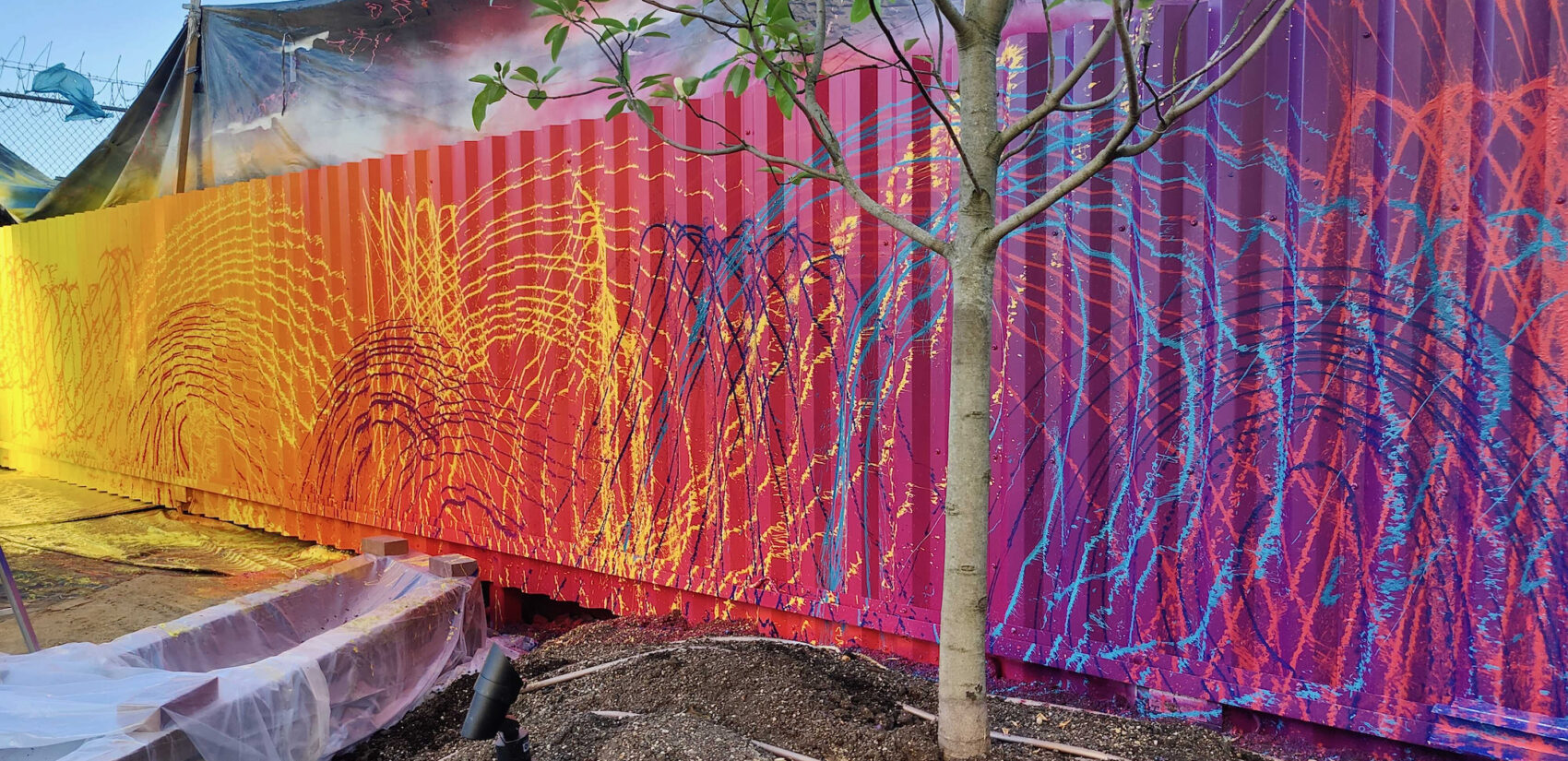 Artist Douglas Hoekzema, aka HOXXOH, created a rainbow-colored underlayer of color, on top of which he sprayed lines of complementary colors through garden hose attachments. (Peter Crimmins/WHYY)