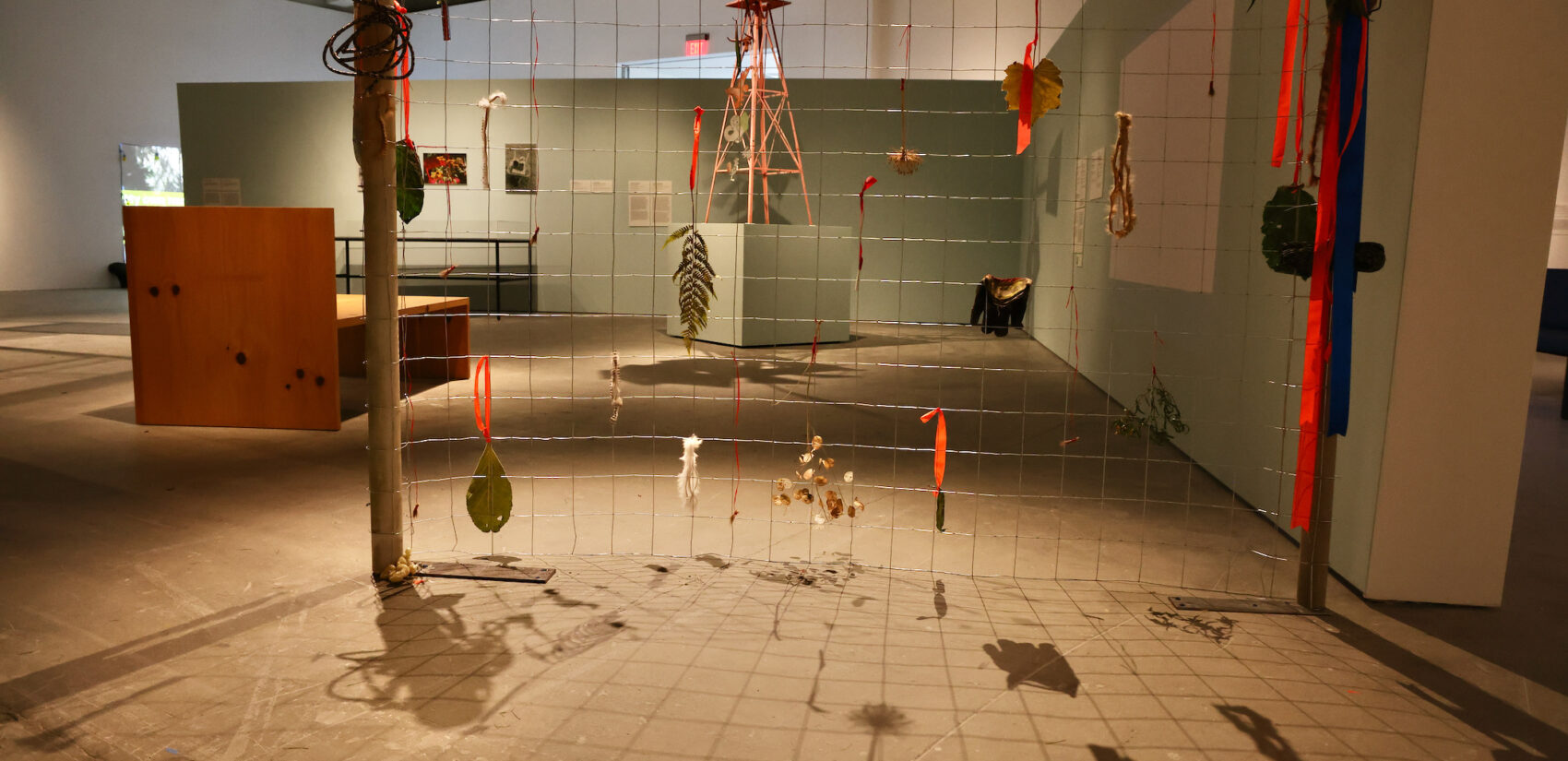 The exhibit ''Where I Learned to Look: Art From the Yard'' brings the language of yard art to the galleries of the Institute of Contemporary Art. In the foreground, ''Fence'' by Janeen Frei Njootli, Gabriielle L'Hirondelle Hill and Tania Willard frames Hiipolito ''Polé'' Hernandez's ''Untitled'' (Windmill).'' (Emma Lee/WHYY)