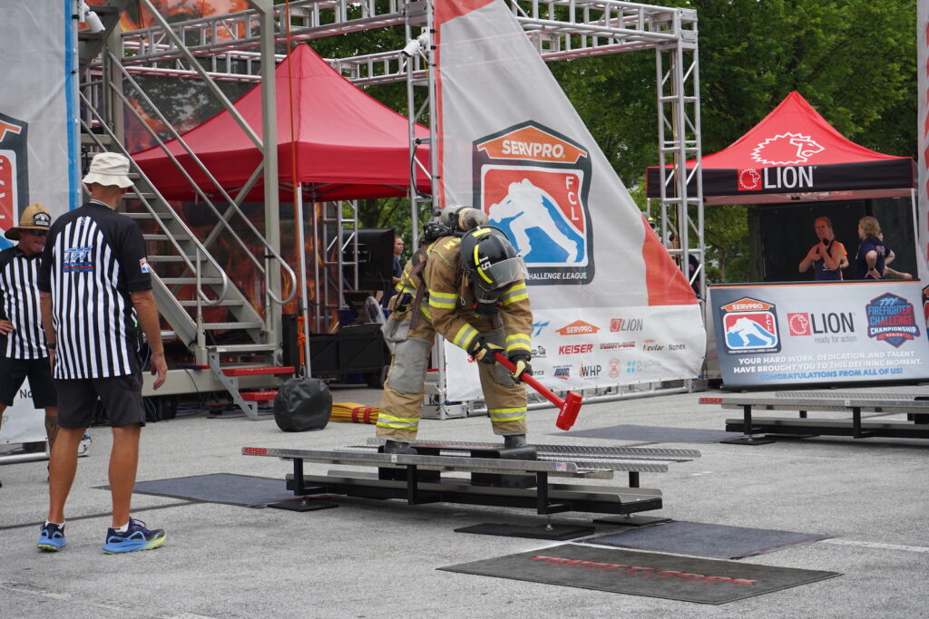 A firefighter slamming a sledgehammer down