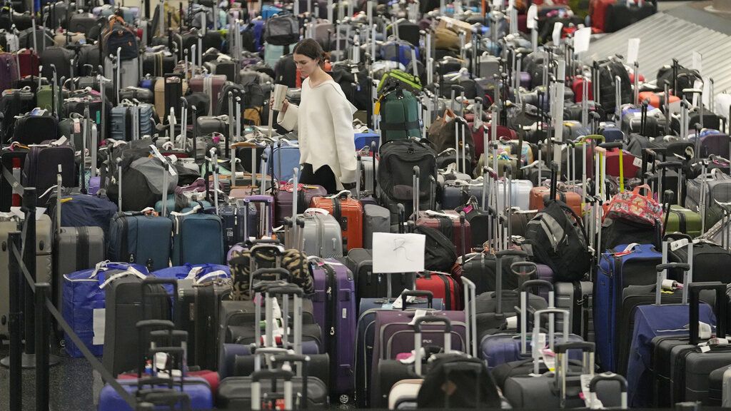 Airport hassle A woman walks through unclaimed bags at Southwest Airlines baggage claim at Salt Lake City International Airport on Dec. 29, 2022. (AP Photo/Rick Bowmer, File)
