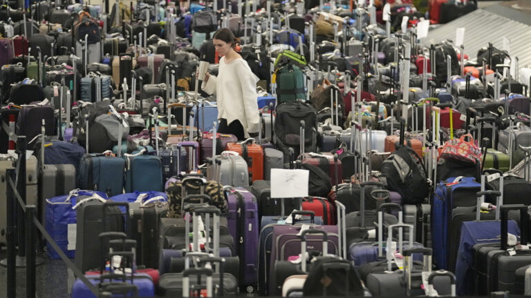 A woman walks through unclaimed bags at Southwest Airlines baggage claim at Salt Lake City International Airport on Dec. 29, 2022. (AP Photo/Rick Bowmer, File)