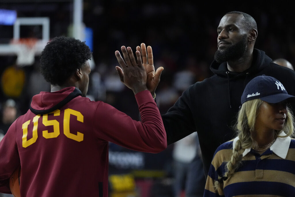 Stanford USC Basketball Southern California guard Bronny James, left, high-fives his father, Los Angeles Lakers' LeBron James, as he warms up before an NCAA college basketball game against Stanford in Los Angeles, Saturday, Jan. 6, 2024. (AP Photo/Ashley Landis)