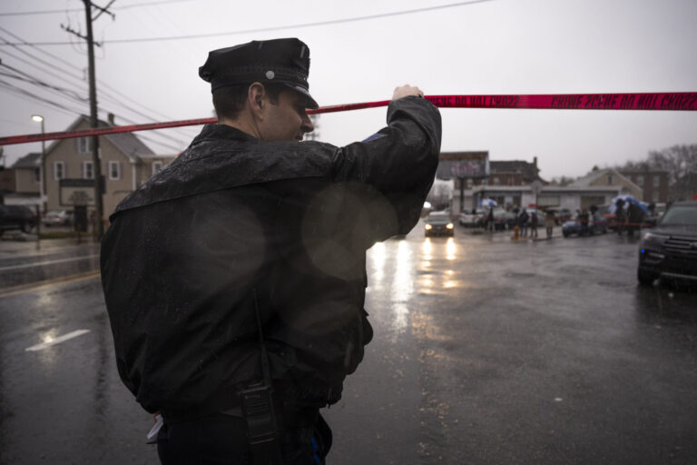 Public Information Officer Eric Gripp works on scene following a shooting in Northeast Philadelphia. (AP Photo/Joe Lamberti)