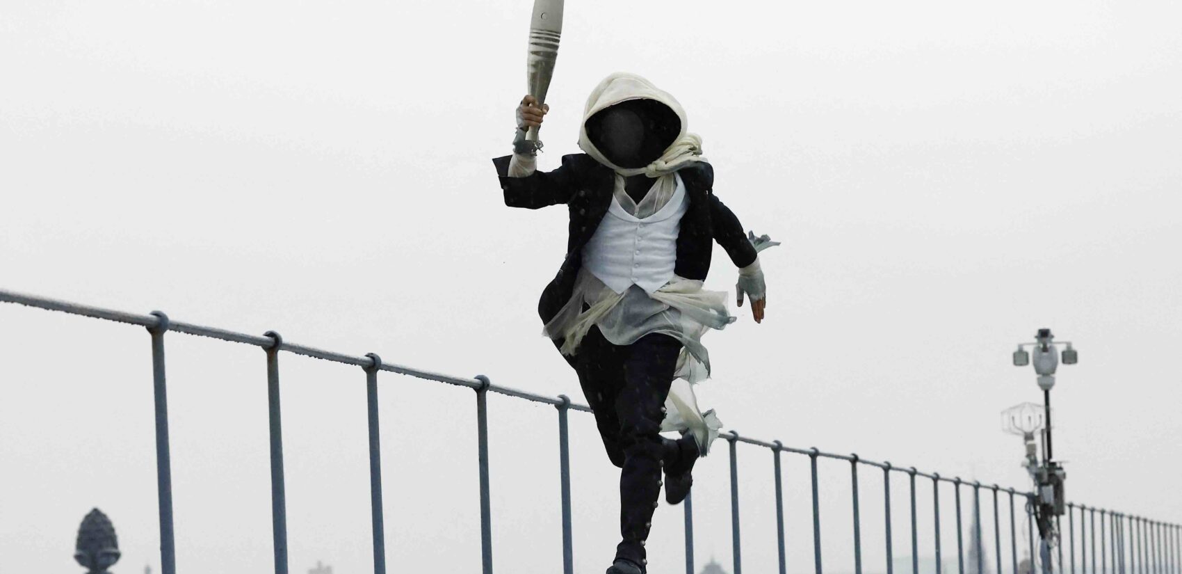 A torch bearer runs atop the Musee d'Orsay, in Paris, France, during the opening ceremony of the 2024 Summer Olympics, Friday, July 26, 2024. (Peter Cziborra/Pool Photo via AP)
