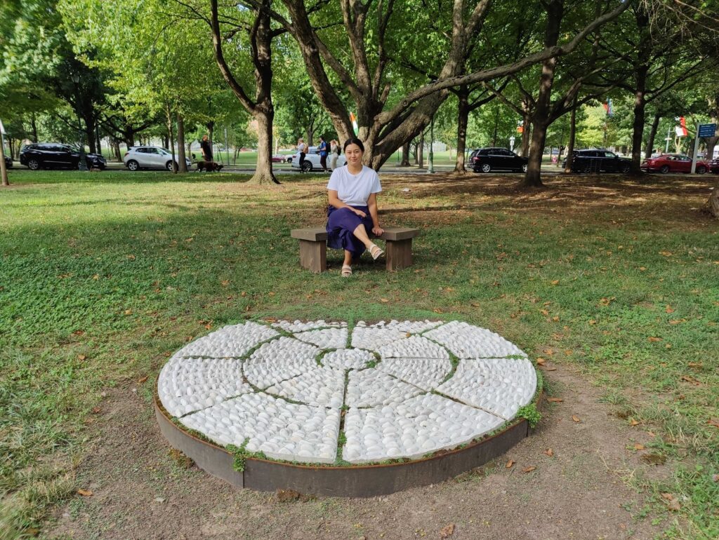 Rachel Hsu sits by her piece