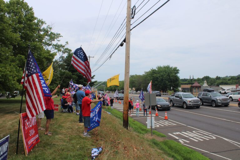 Dozens of Trump supporters waved flags and signs by the side of the road in Doylestown on July 20, 2024. (Emily Neil/WHYY)