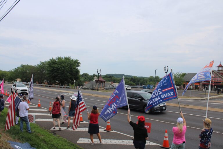 Dozens of Trump supporters waved flags and signs by the side of the road in Doylestown on July 20, 2024. (Emily Neil/WHYY)