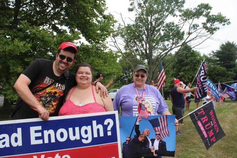 From left, Charlie Patton, 35, of Warrington, Amanda Supplee, 34, of Chalfont, and Erin Gardner, 51, of Warrington hold signs supporting Trump for president. (Emily Neil/WHYY)