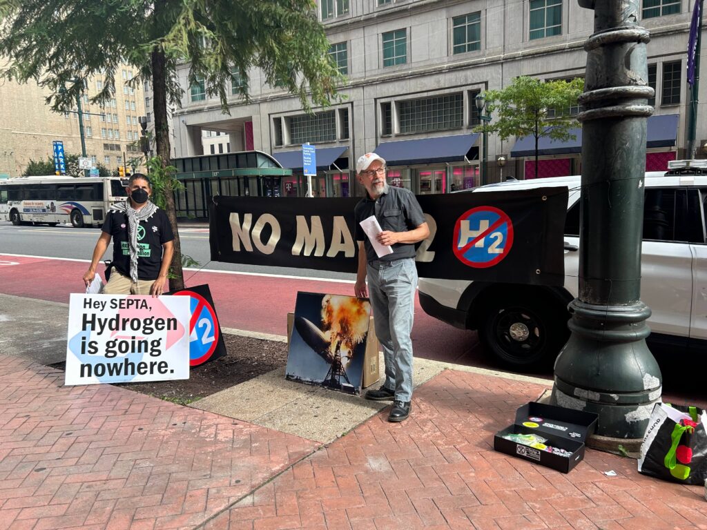 hydrogen-energy-protesters climate activists hold signs saying Hydrogen is going nowhere and No Mach2