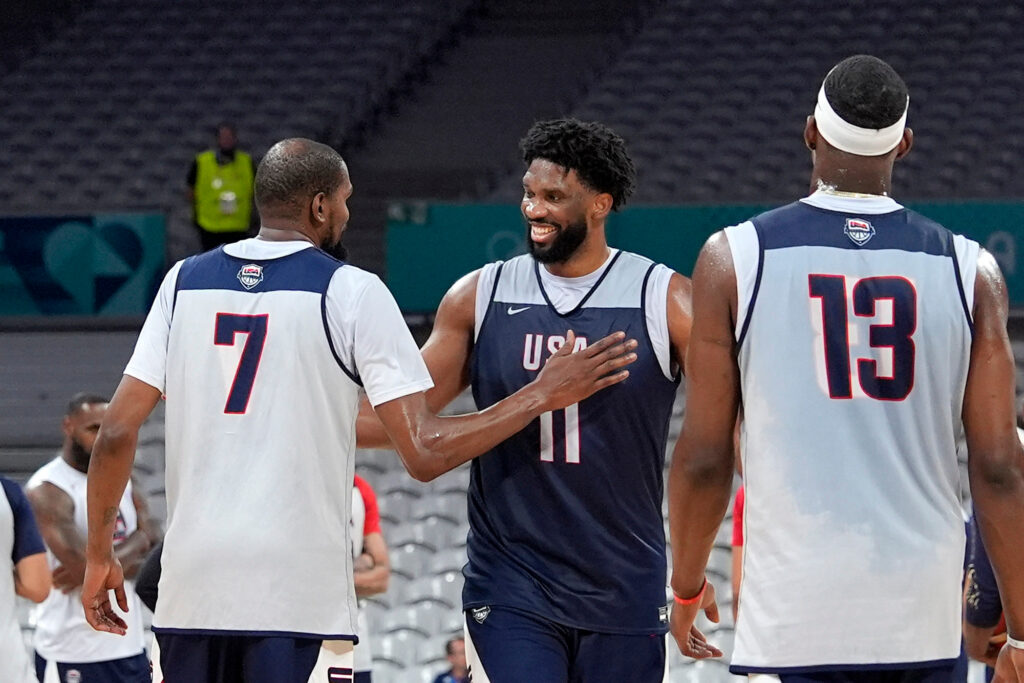 joel-embiid-team-usa-2024-07-24 United State's Kevin Durant, left, pats Joel Embiid, center, after practice as Bam Adebayo watches during men's basketball practice at the 2024 Summer Olympics, Wednesday, July 24, 2024, in Villeneuve-d'Ascq, France. (AP Photo/Mark J. Terrill)