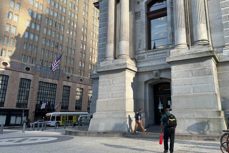 Philadelphia workers head into City Hall's employee entrance on Friday, July 19, 2024, during the first week of the return-to-office mandate. (Kristen Mosbrucker-Garza/WHYY News)