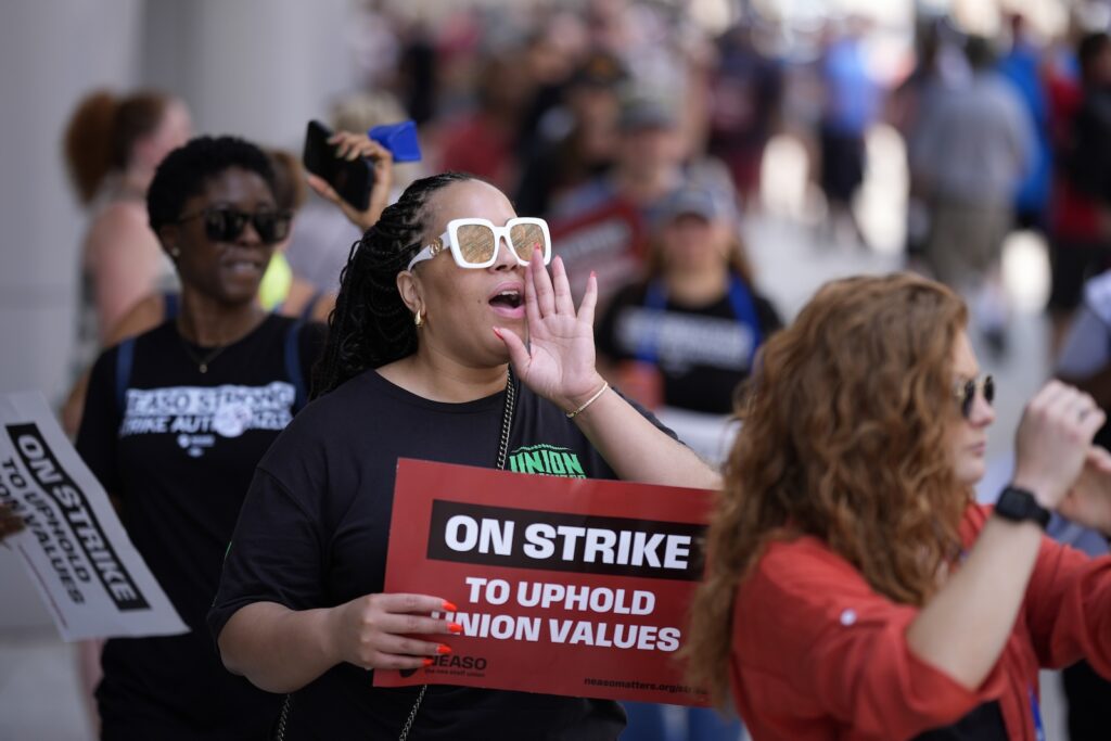 A demonstrator chants while picketing in support of the National Education Association Staff Organization outside the Pennsylvania Convention Center, Friday, July 5, 2024, in Philadelphia.