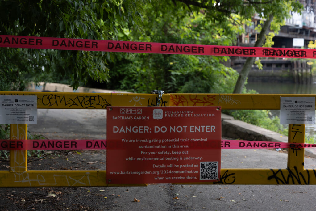 A sign on a gate stating that part of the Bartram's Garden hiking trail in Philadelphia is closed
