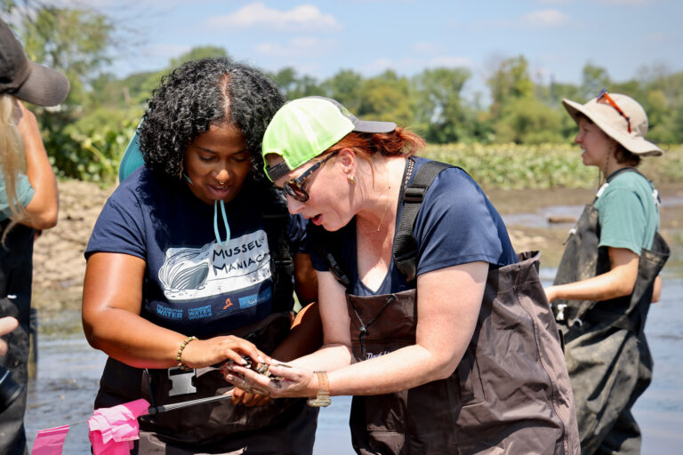 Colleen Winslow and Bria Wimberly look at mussels