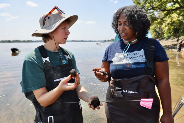 Colleen Winslow and Bria Wimberly speaking holding mussels