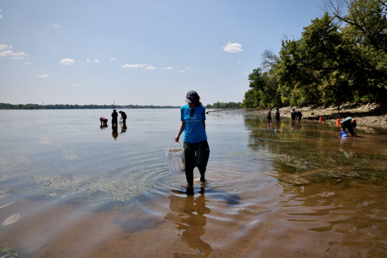 Michelle Mullin holds a bucket standing in the water