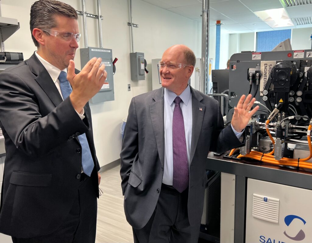Battery-Innovation-Center-ribbon-cutting-7 Chris Coons and a person look at the technology