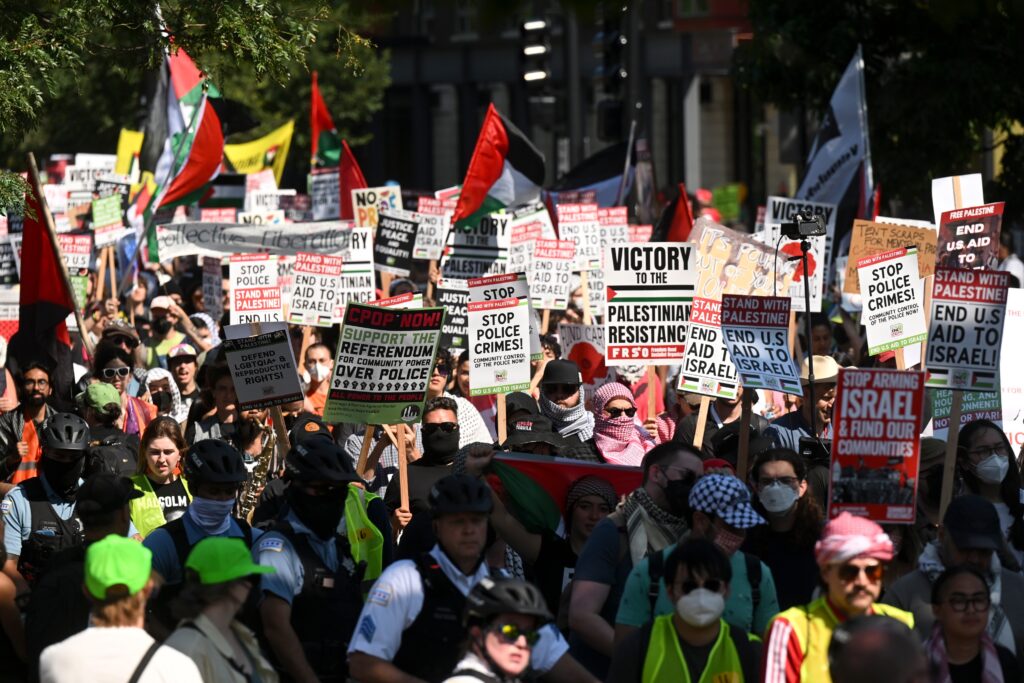 DNC-Gaza-protesters-2024-08-19 Protesters march holding pro-Palestinian signs