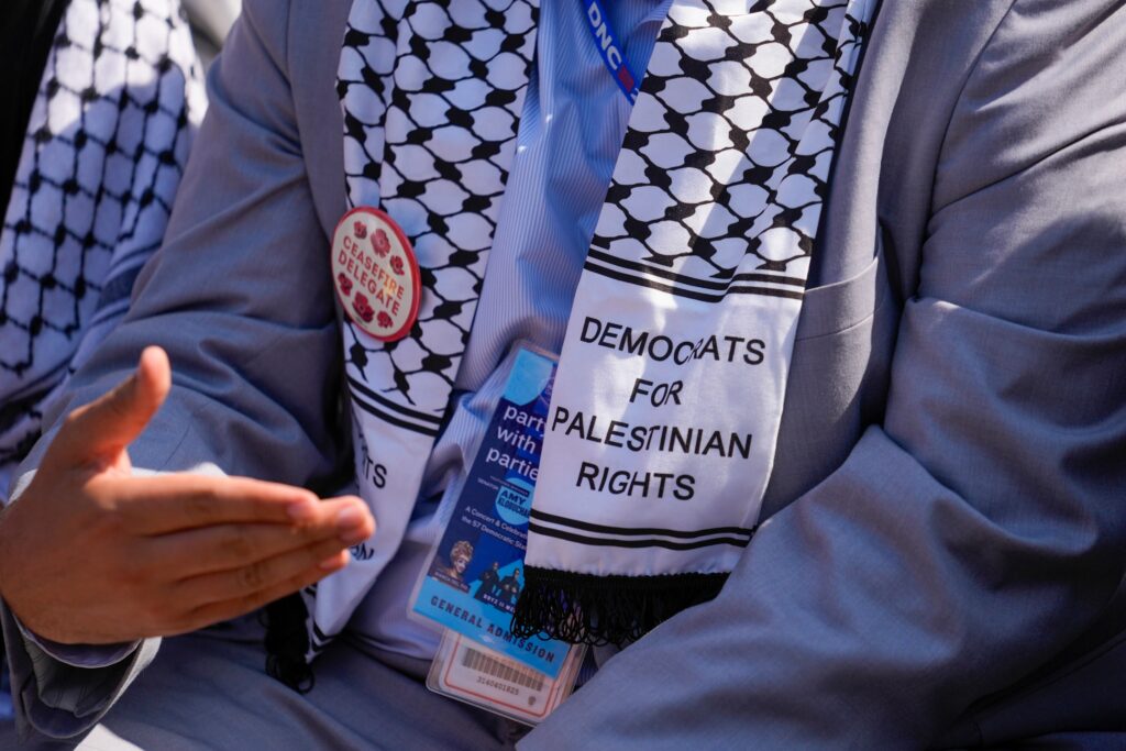 DNC-pro-Palestinian-delegates-2024 an up-close shot of a delagate shows a scarf reading DEMOCRATS FOR PALESTINIAN RIGHTSS and a pin reading CEASEFIRE DELEGATE