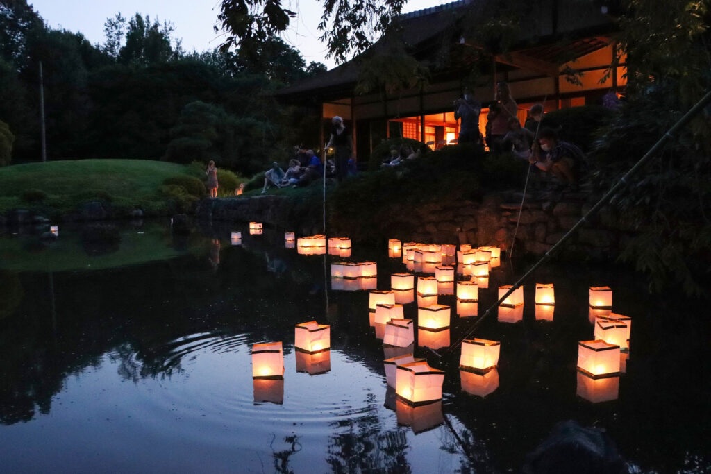 Lantern Floating_3_Millie Chen Japanese paper lanterns float on the water with candles lit inside them