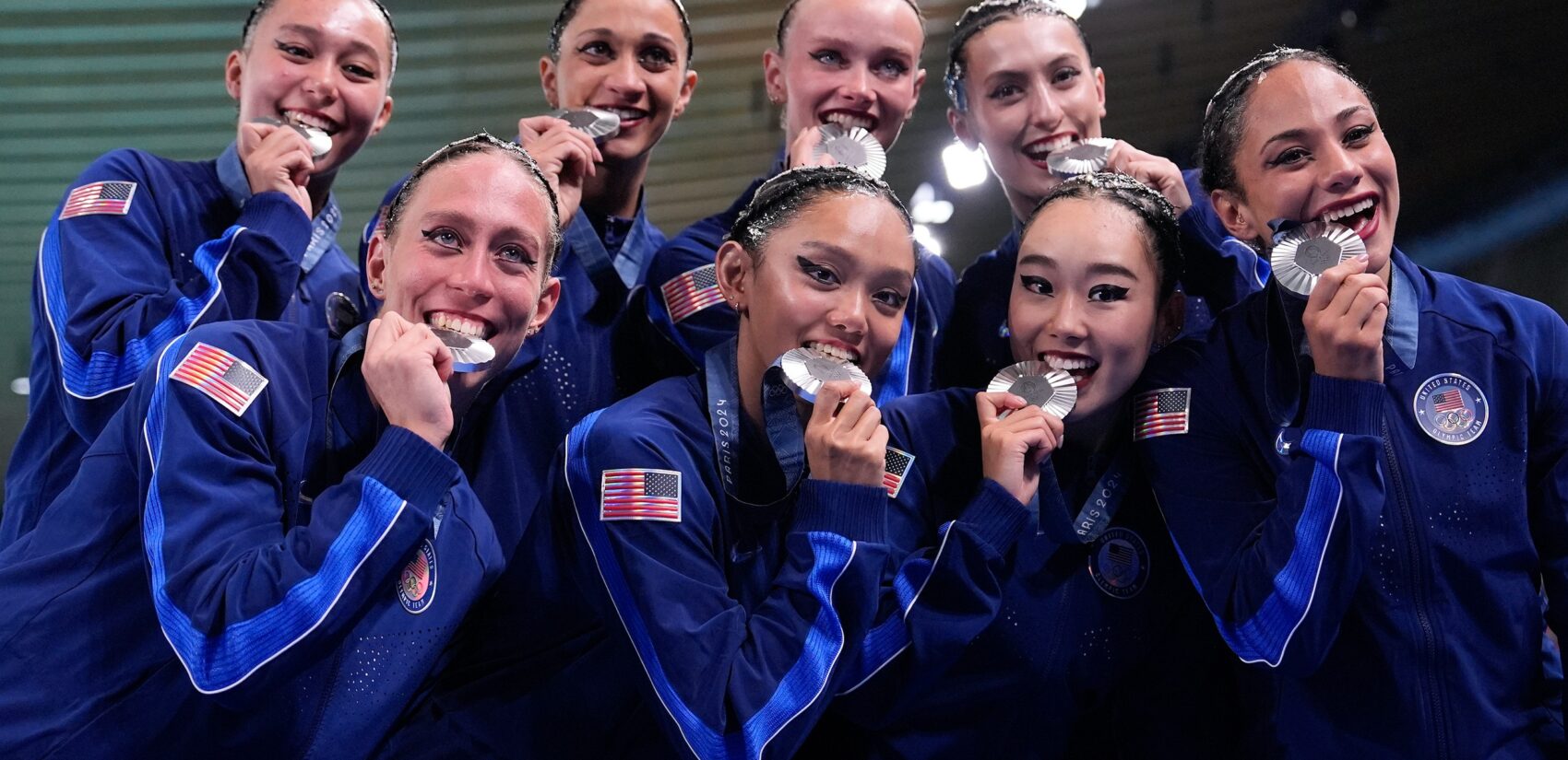 Megumi Field bites her medal with the U.S. team