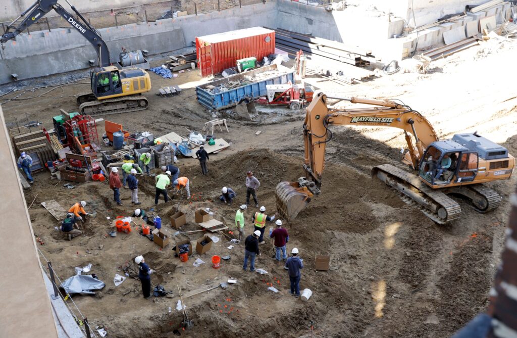 Old-City-Philadelphia-coffins-excavate Workers with machines excavate coffins from a construction site in the Old City