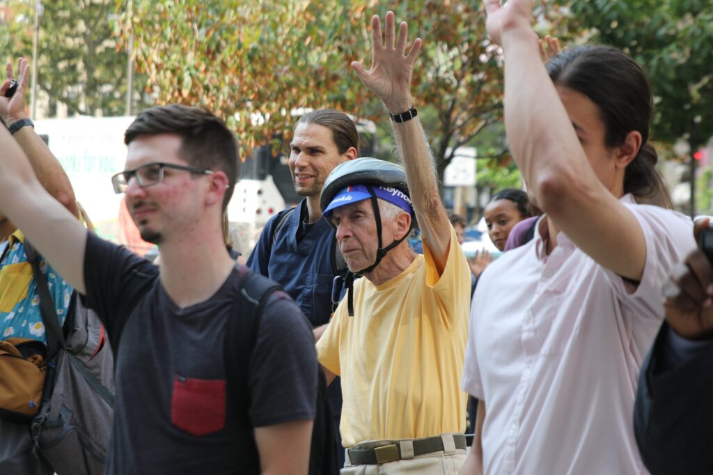 Multiple cyclists raise their hands