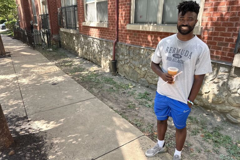 Keith Smith with an iced coffee on the sidewakl