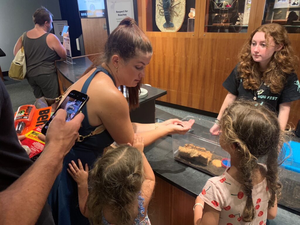 academy_natural_sciences_bug_festival_philadelphia A woman shows two children a cockroach at Bug Fest in Phialdelphia