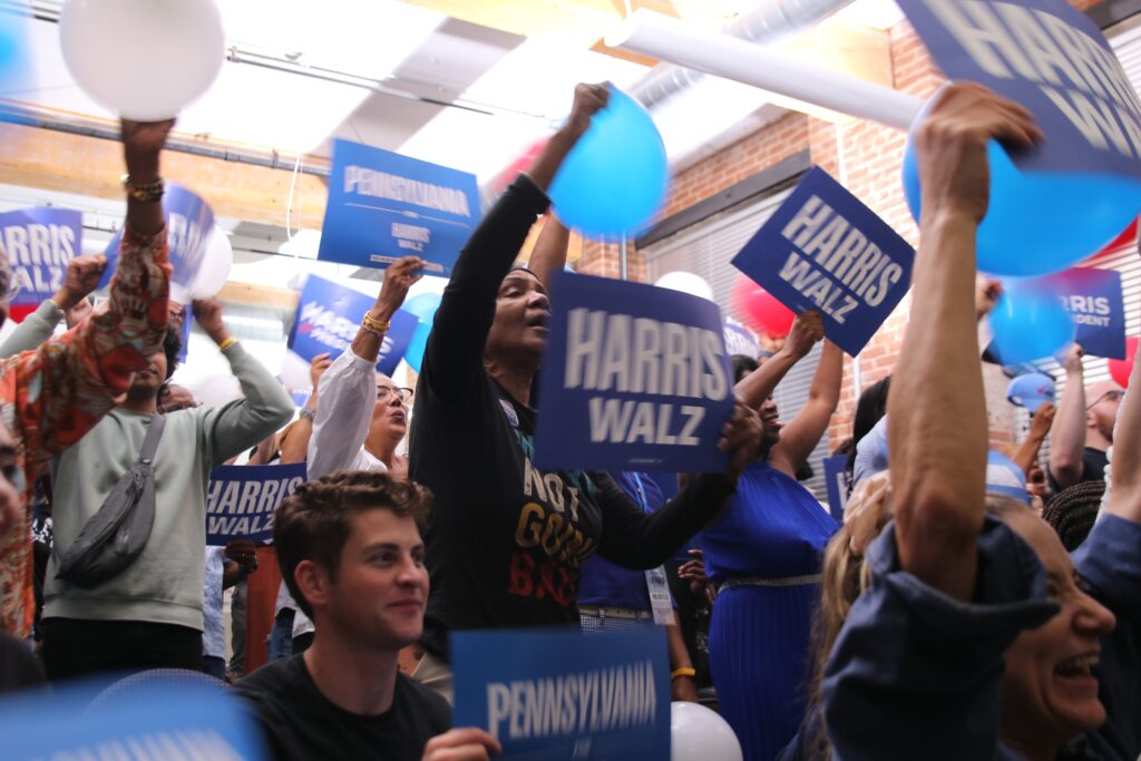 manayunk-philadelphia-watch-party-dnc-1 attendees hold Harris Walz signs and cheer