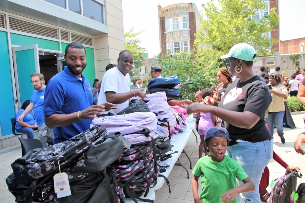 north-philadelphia-backpack-giveaway-2024-08-15 Donta Rose and and Kelvin Jeremiah at a table with backpacks