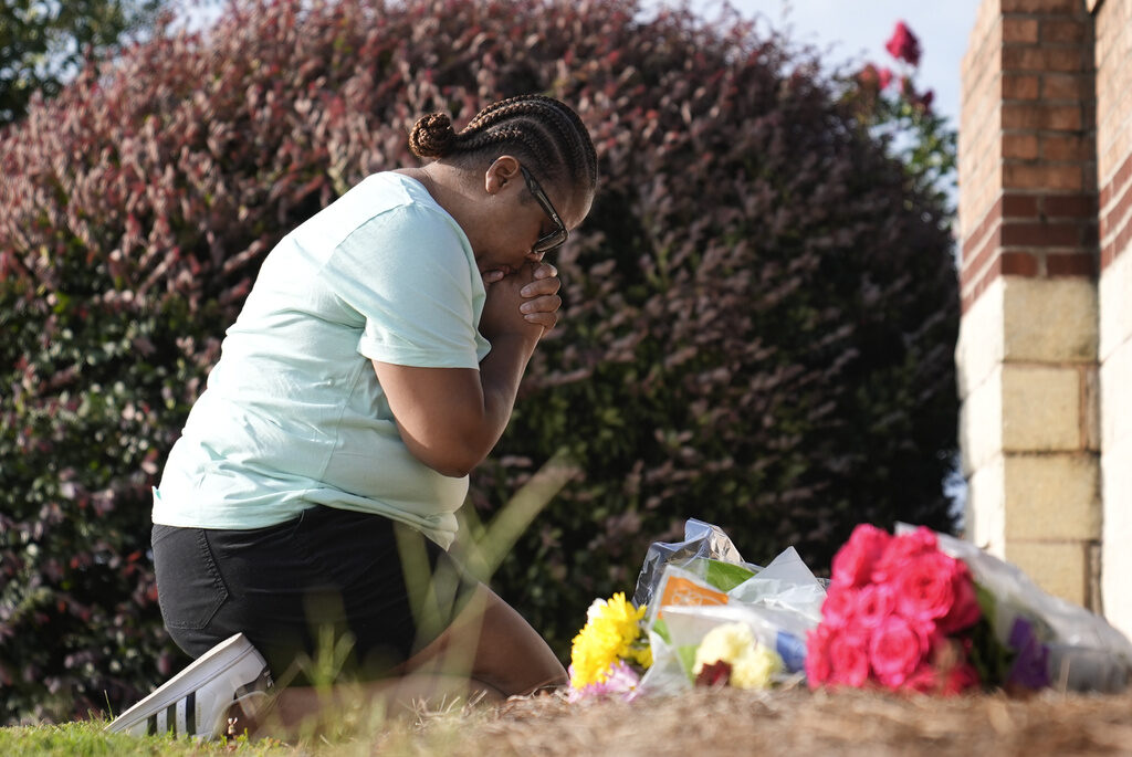 Georgia School Shooting Linda Carter, of Grayson, Ga., kneels near Apalachee High School to place flowers as she mourns for the slain students and teachers on Thursday, Sept. 5, 2024, in Winder, Ga.