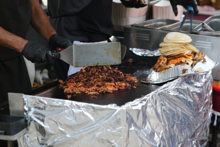 meat being chopped next to tortillas