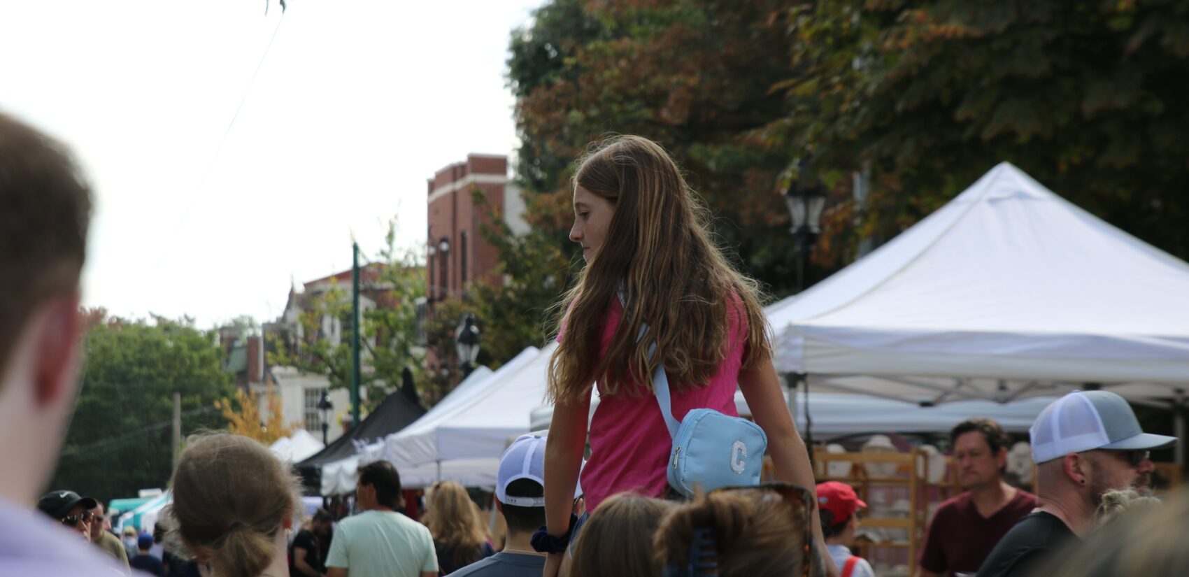 a child on someone's shoulders in a crowd