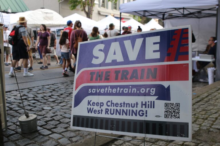 a sign reads SAVE THE TRAIN Keep Chestnut Hill RUNNING!
