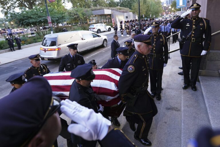 Officers carry the casket