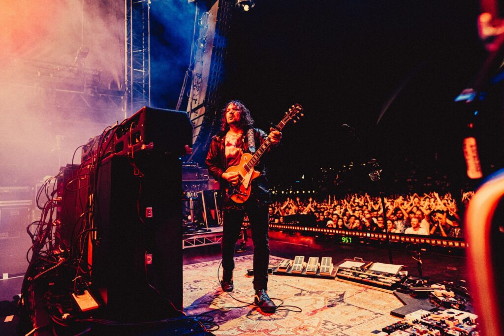 TheWarOnDrugs_CharlieHardy-4118 Adam Granduciel playing guitar onstage
