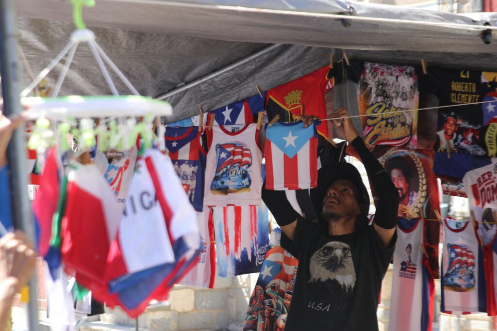 feria-del-barrio-2024-5 a person hangs t-shirts