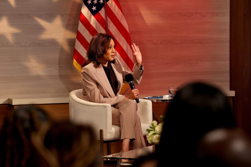 kamala-harris-2024-09-17-WHYY-2 Kamala Harris raises her hand while sitting holding a microphone
